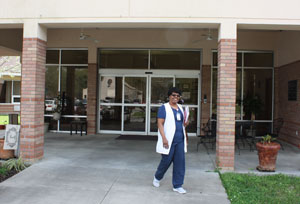 Exterior shot of nurse standing outside building.
